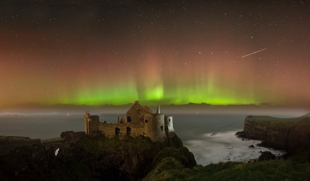 İrlanda - Dunluce Kalesinin harabelerinin üstünde Kuzey Işıkları